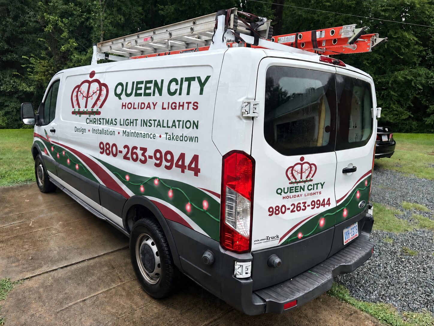 Queen City Holiday Lights work van with ladders on the roof rack and Christmas light installation lettering